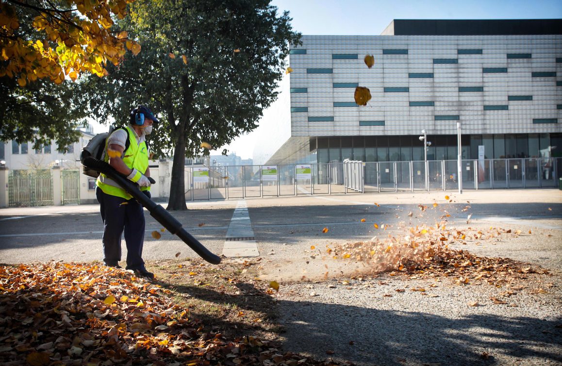 Dipendente Iren si occupa della pulizia stradale raccogliendo le foglie