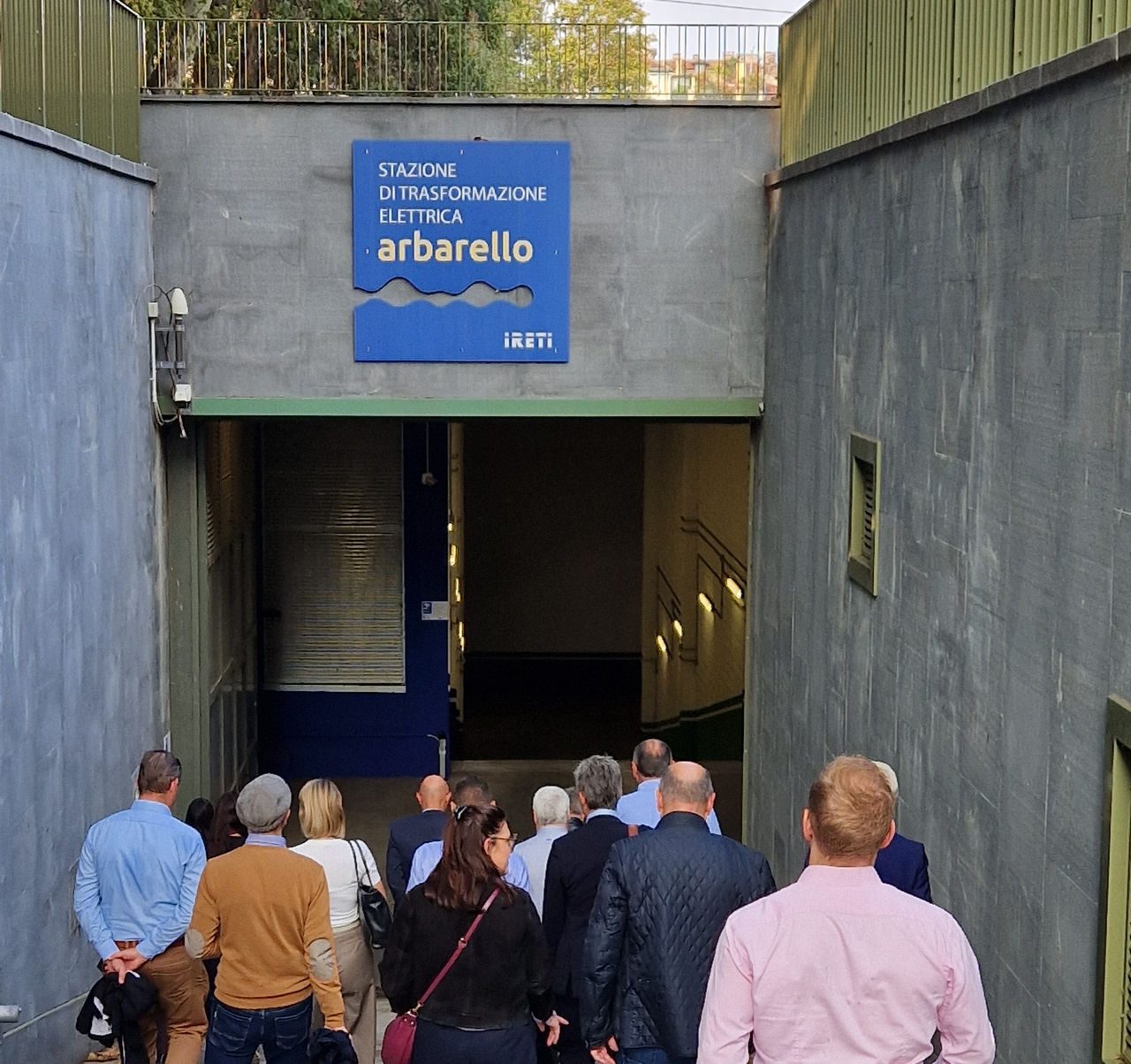 Un gruppo di persone scende verso l’ingresso della stazione di trasformazione elettrica Arbarello di Ireti, a Torino, durante una visita tecnica guidata.