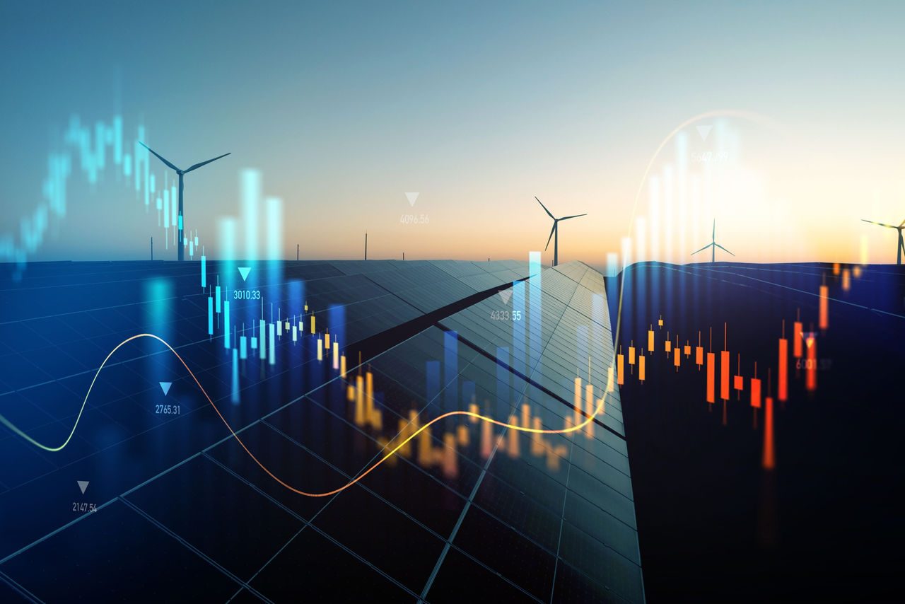 Grafico finanziario trasparente sovrapposto a pannelli solari e turbine eoliche al tramonto, a rappresentare l’andamento del costo dell’energia nel contesto della transizione energetica.