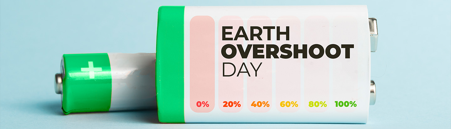 Composizione concettuale con batterie allineate su sfondo blu pastello e nuvole bianche, a simboleggiare il consumo eccessivo di risorse in occasione dell’Earth Overshoot Day.