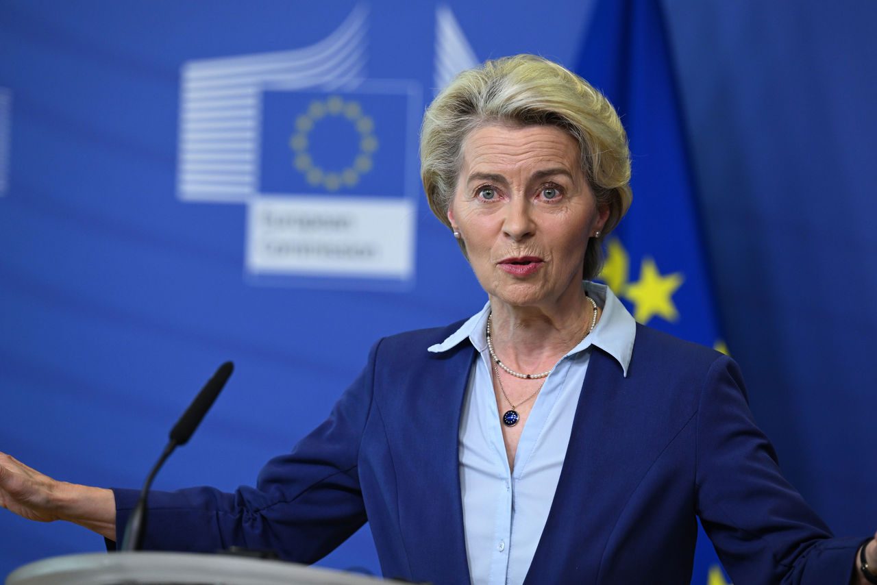 Ursula von der Leyen parla durante una conferenza stampa della Commissione Europea, con bandiere dell'Unione Europea sullo sfondo.