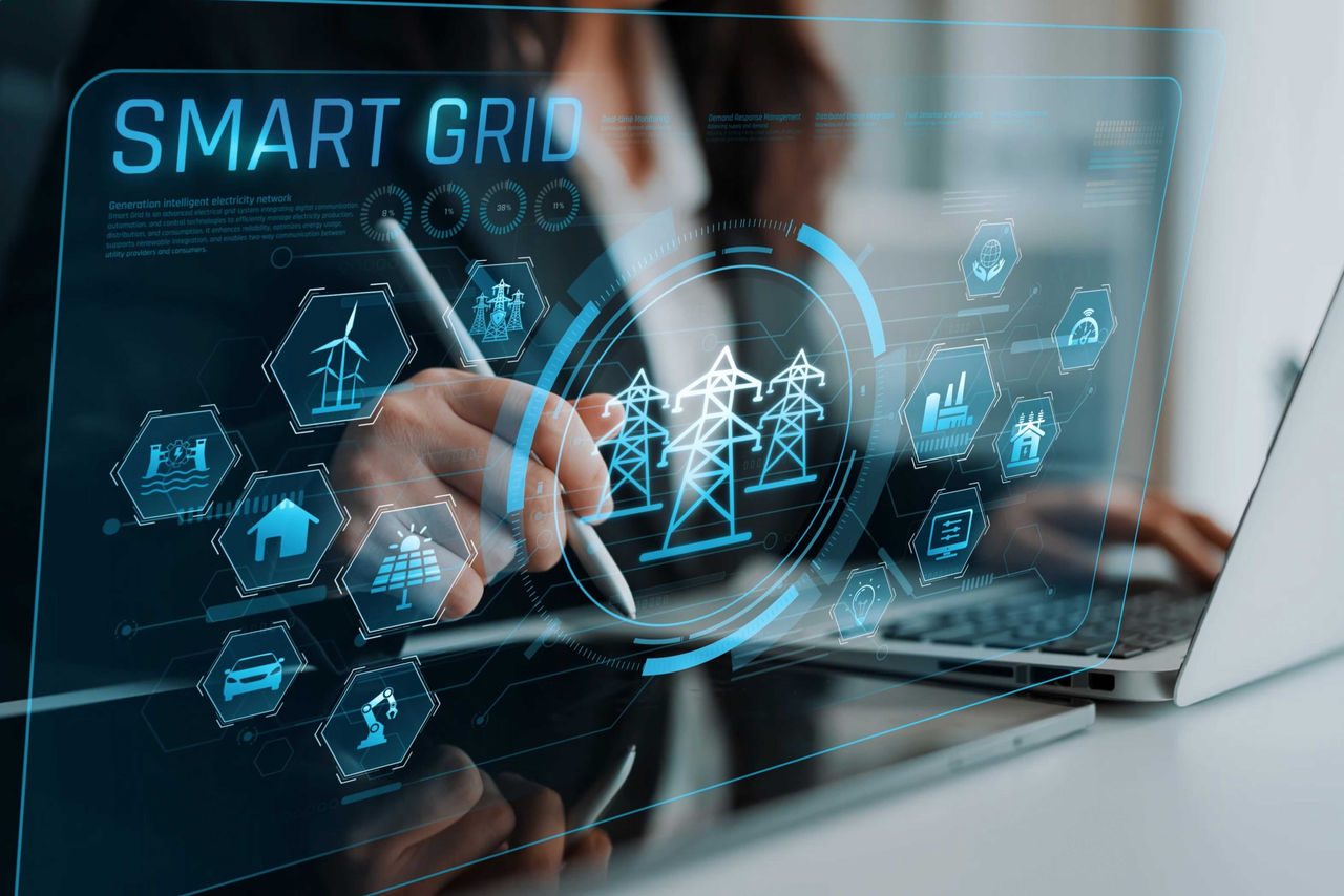 grafica con la scritta smart grid in sovrapposizione mezzo busto di donna che lavora alla scrivania con laptop aperto