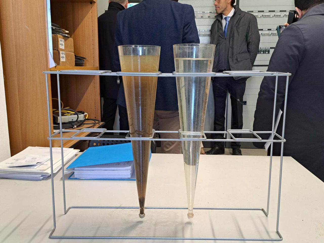 uomo con guanti e pettorina gialli, addetto alla raccolta dei rifiuti, duranto lo smistamento  delle bottiglie di vetro