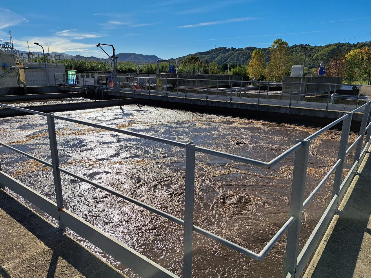 uomo con guanti e pettorina gialli, addetto alla raccolta dei rifiuti, duranto lo smistamento  delle bottiglie di vetro