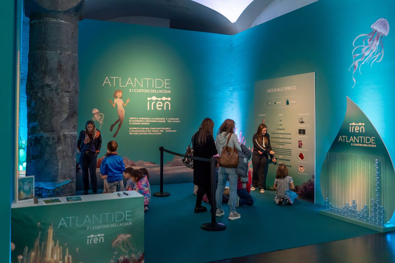 Bambini e famiglie partecipano al percorso interattivo “Atlantide e i custodi dell’acqua” di Iren, con pannelli e attività educative dedicate al risparmio idrico.
