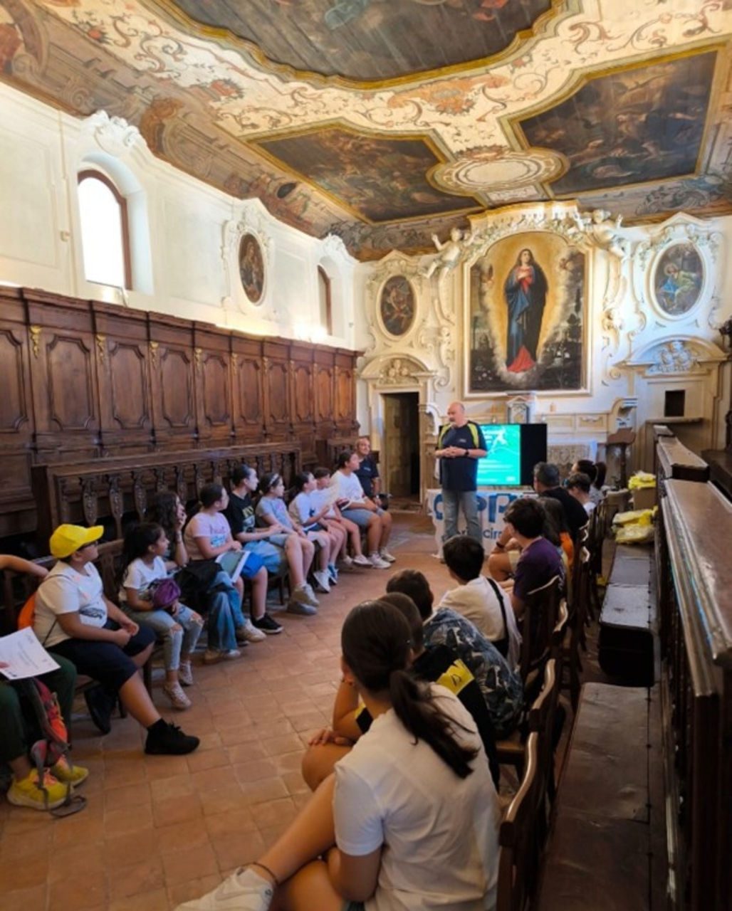 studenti e studentesse che ascoltano un tecnico di Iren Energia, all'interno della seicentesca cappella della Congrega dell’Immacolata