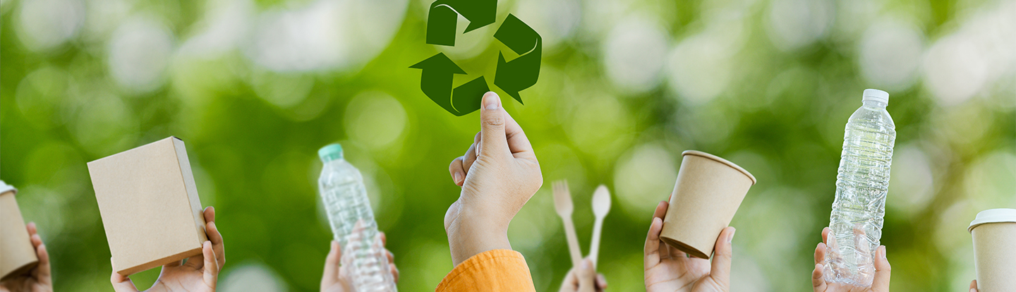 Mani che tengono in mano oggetti che si possono reciclare nella plastica o nella carta