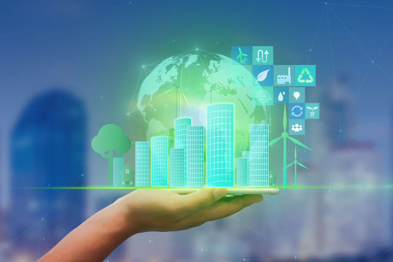 mano che tiene il telefono cellulare con ologramma del concetto di green city e zero emissioni