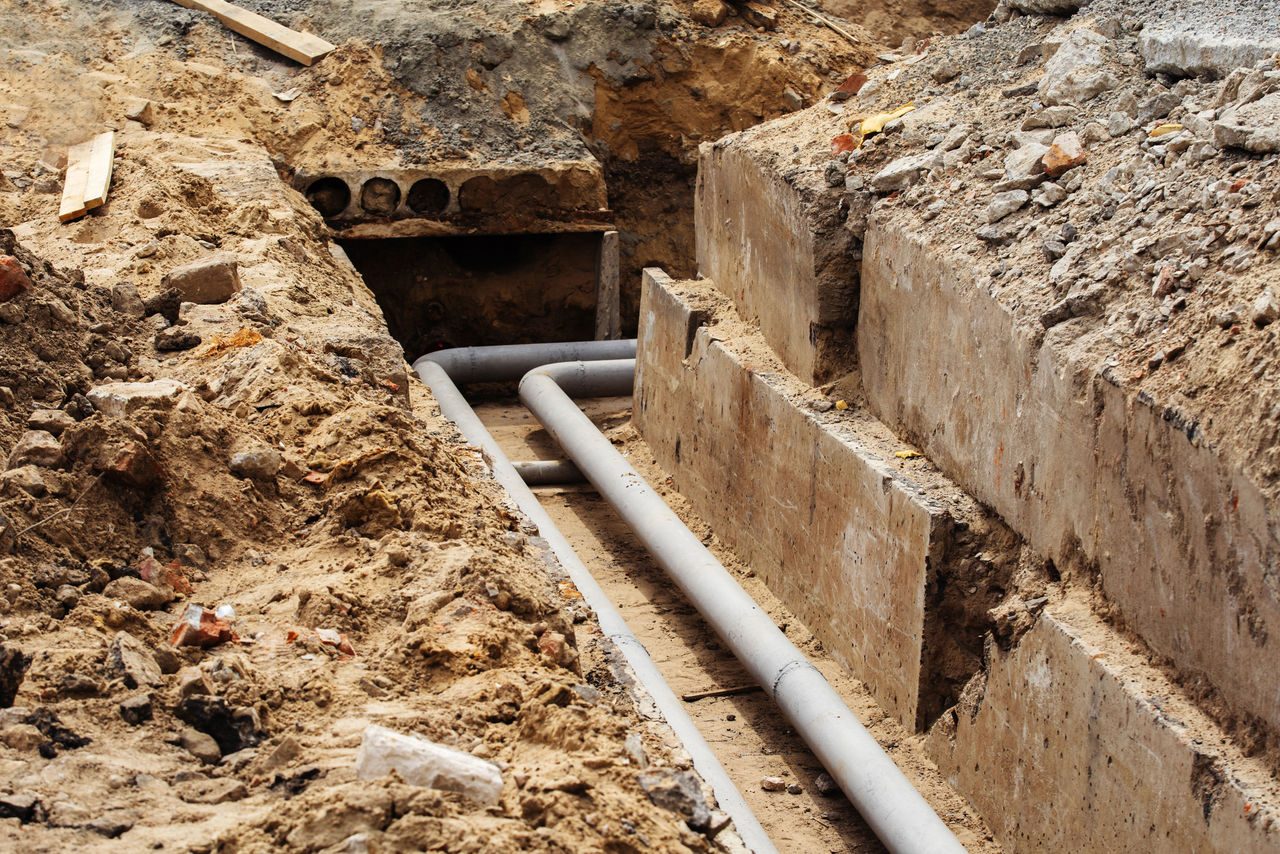 Trincea con tubi metallici sostituiti e base in cemento