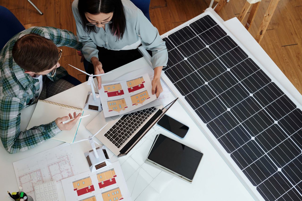 due ingegneri che progettano pannelli fotovoltaici ad una scrivania con i pc 