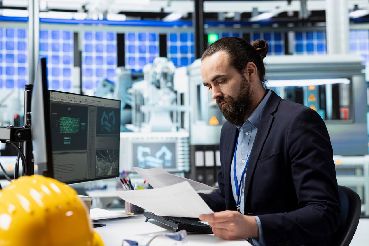 uomo studia una carta di progetto in studio