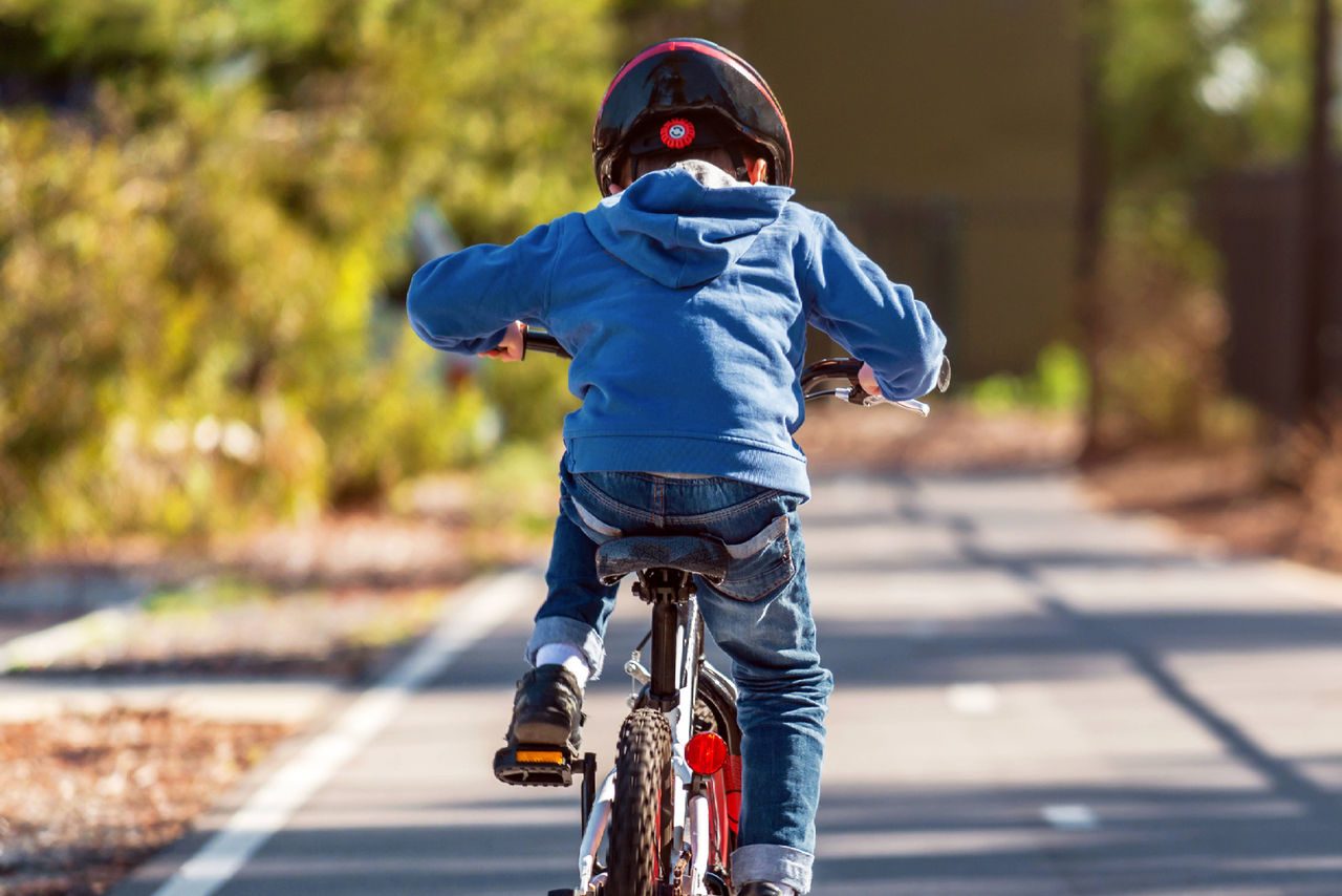 bimbo di spalle in bicicletta