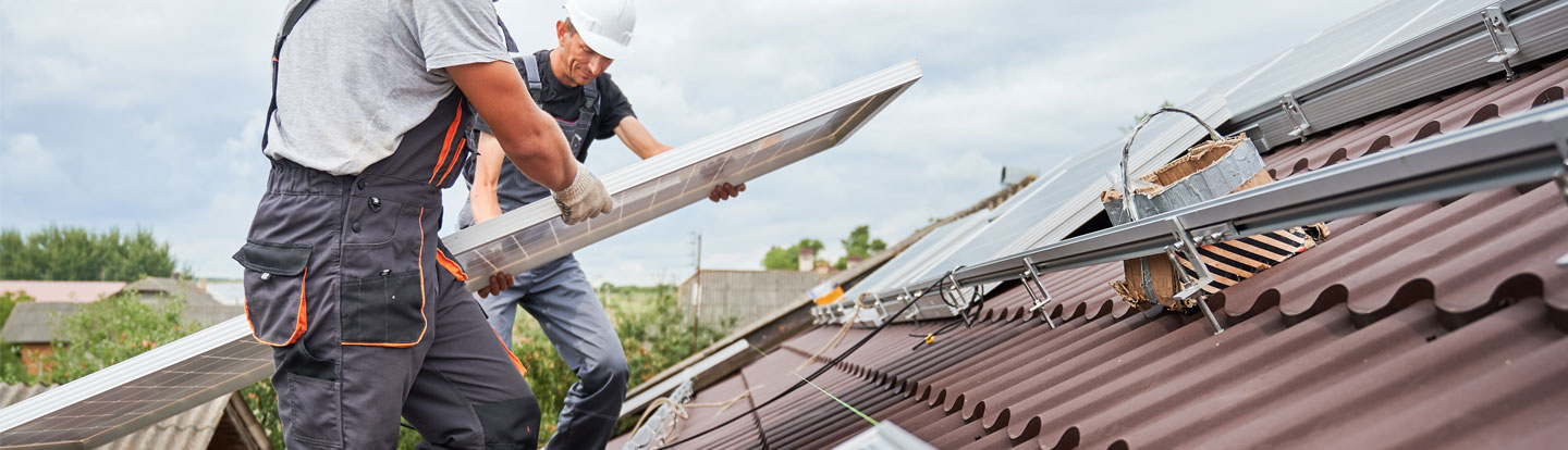 operai installano pannelli solari sul tetto