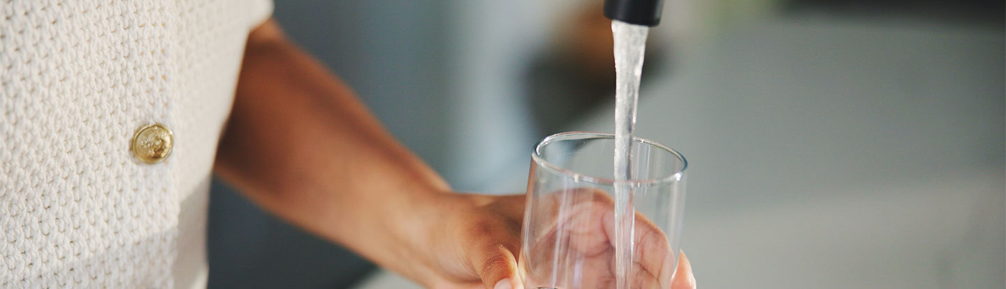 bicchiere sotto getto d'acqua del rubinetto