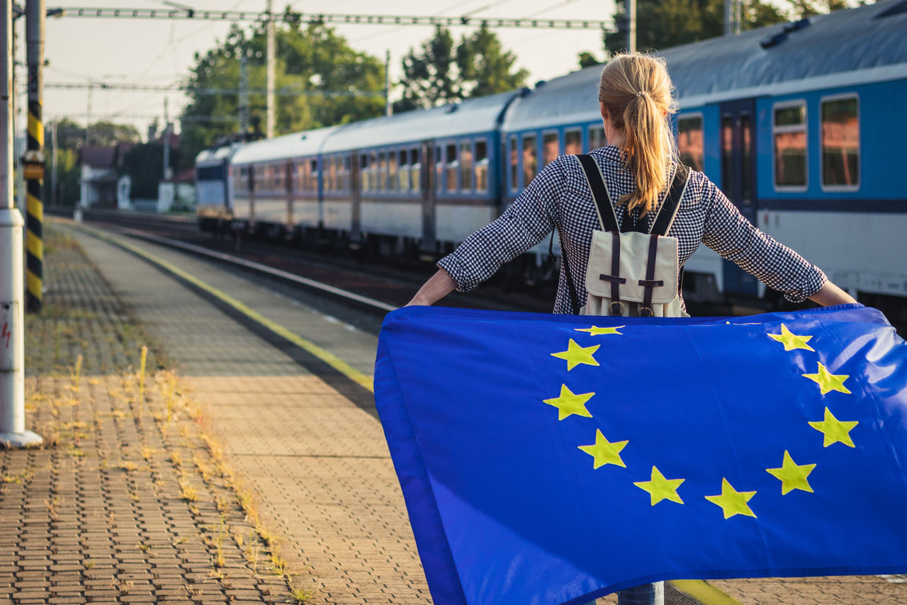 ragazza con bandiera Europa in stazione