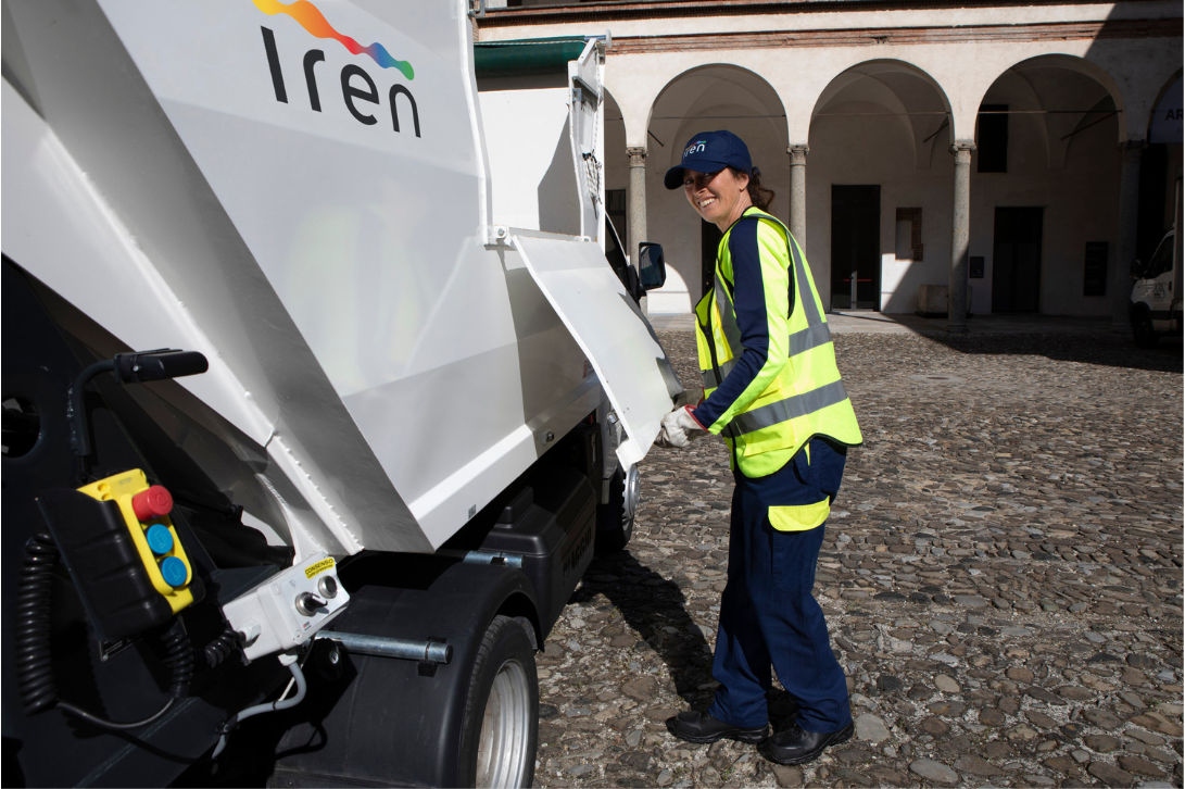 Operatrice ecologica Iren con mezzo per la pulizia delle strade
