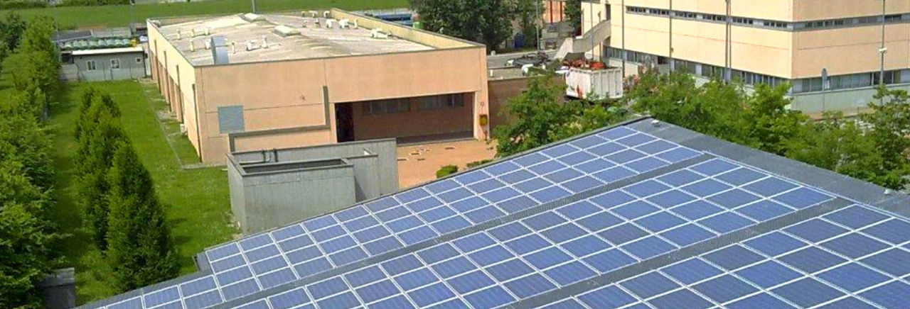 Vista dall'alto di un edificio sul cui tetto ci sono una serie di pannelli fotovoltaici