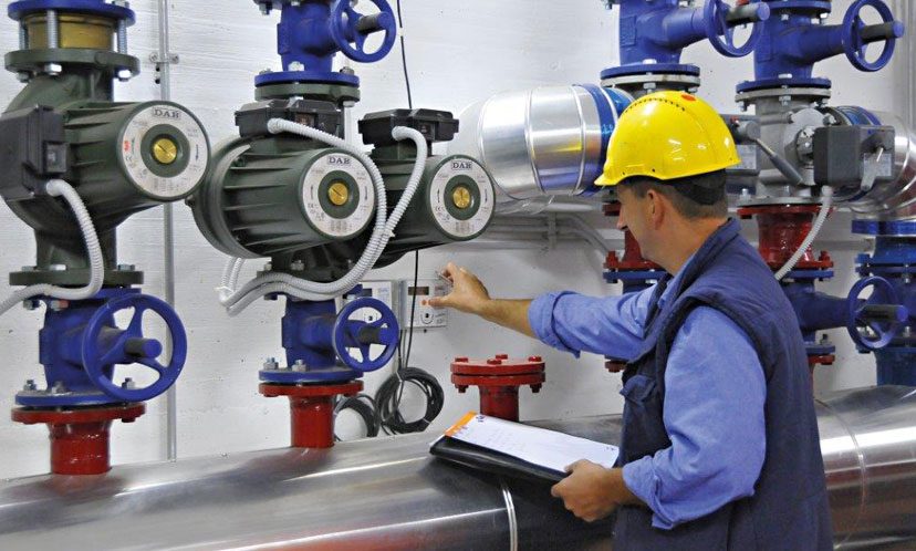 Dipendenti con caschetto di protezione si occupa della verifica di un impianto termico